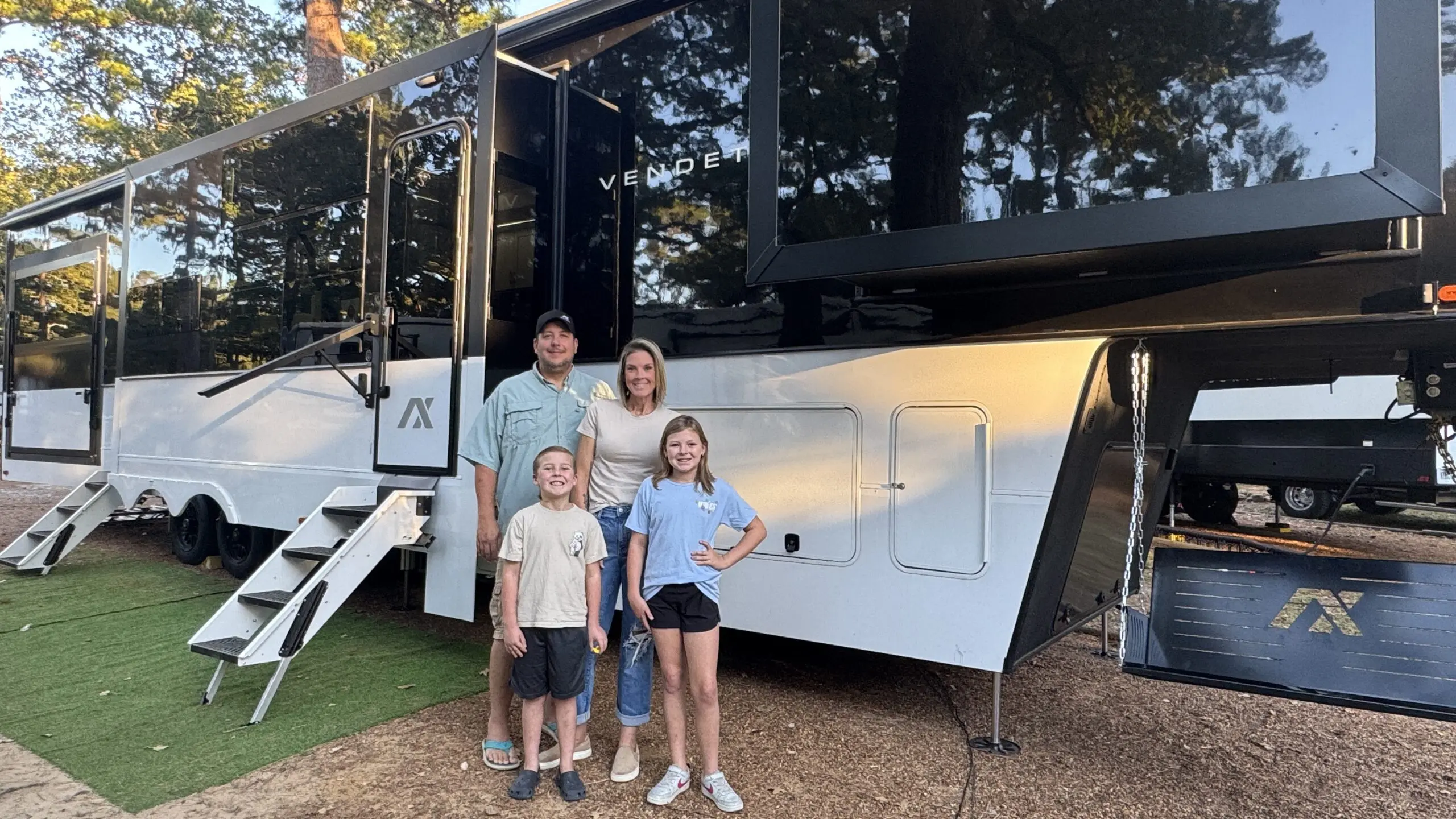 The Lawings family of four standing in front of their Vendetta fifth wheel RV for a full-time RV family blog